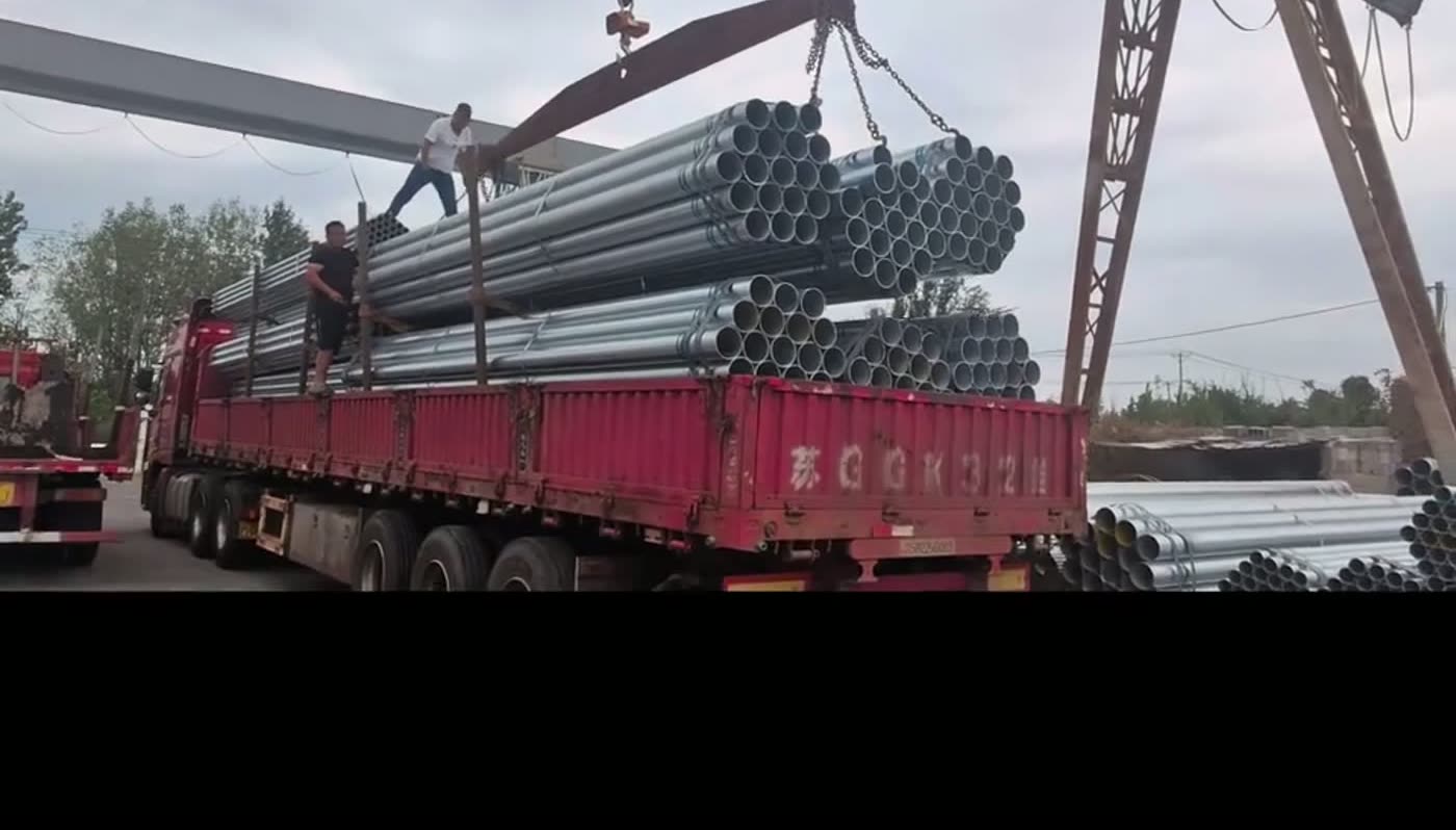Galvanized pipe bundles lifted onto the truck for loading